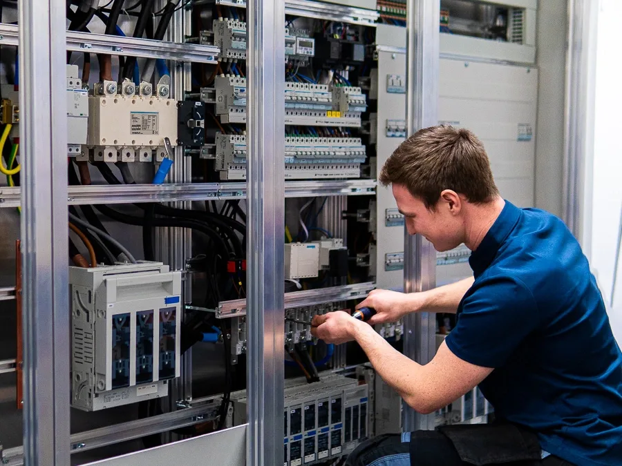 Technician working on an industrial electrical control panel.